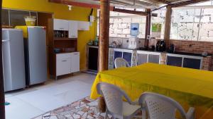 a kitchen with a table with a yellow table cloth at Chalé a beira mar ilhéus in Ilhéus