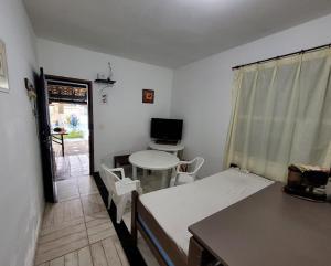 a room with a bed and a table and a desk at Casa em Ilha Comprida in Ilha Comprida