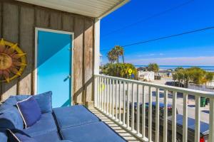 a balcony with a blue couch and a view of the beach at Hang 6 in Folly Beach