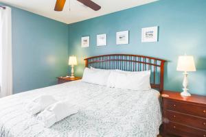 a bedroom with a bed with white sheets and a blue wall at Hang 6 in Folly Beach