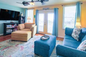 a living room with a couch and chairs and a tv at Hang 6 in Folly Beach +39 photos