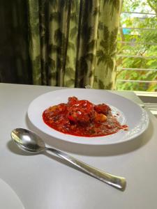 a plate of food on a table with a spoon at Top Comfort in Kolkata