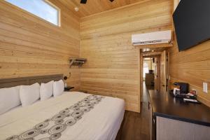 a bedroom with a bed in a room with wooden walls at Arches Hut in Moab
