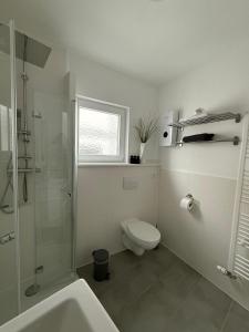 a white bathroom with a toilet and a shower at Ferienwohnung in der Innenstadt in Euskirchen