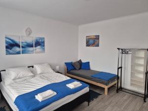 a bedroom with a bed and a small bed and a bench at Leander Apartman in Gyömrő