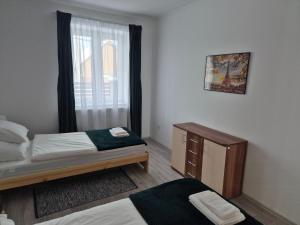 a small bedroom with a bed and a window at Leander Apartman in Gyömrő +2 photos