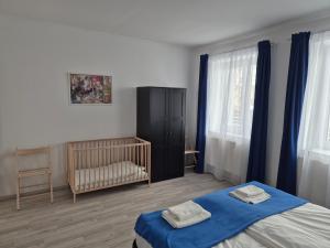 a bedroom with a bed and a crib in it at Leander Apartman in Gyömrő
