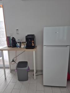 a kitchen with a table and a white refrigerator at Leander Apartman in Gyömrő