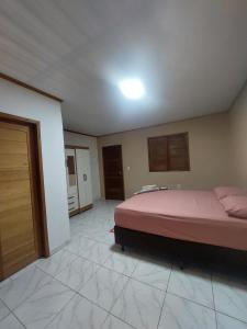 a bedroom with a bed in the middle of a room at Qroom Janaina in Cruzeiro do Sul +8 photos