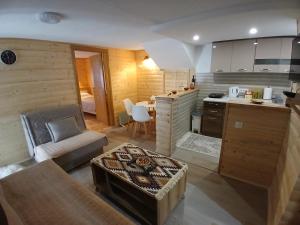 a kitchen and a living room with a couch and a table at Apartman Bakic in Kolašin +12 photos