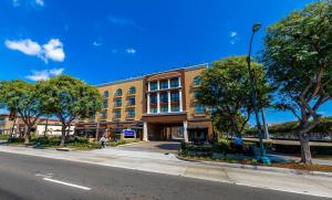 a building on the side of a street with trees at Grand Legacy At The Park in Anaheim