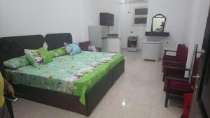 a bedroom with a bed with a green comforter at Grand Plaza Apartment in Marsa Alam City