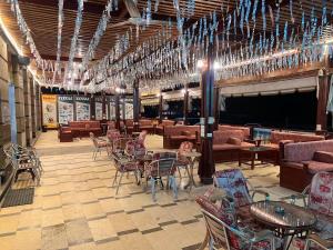 a restaurant with tables and chairs and chandeliers at Grand Plaza Apartment in Marsa Alam City