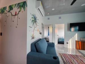 a living room with a blue couch and a tv at The Palm at Life's a Beach in Uvita