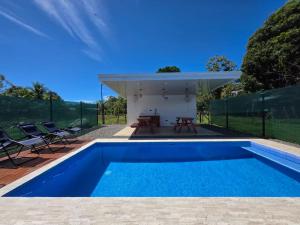 a swimming pool in a backyard with a house at The Palm at Life's a Beach in Uvita