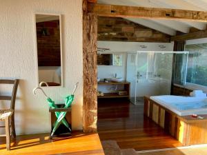 a bathroom with a tub and a shower in a room at Hospedaria Ponta da Piteira in Imbituba