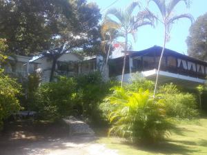 a house with palm trees in front of it at Villa Mar Sosua in Sosúa