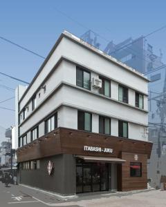 a tall white and brown building on a street at Tokyo Guest House Itabashi-juku in Tokyo