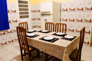 a kitchen with a table with chairs and a refrigerator at Ybirá - Casa Inteira no Centro de Alter do Chão in Alter do Chao +8 photos