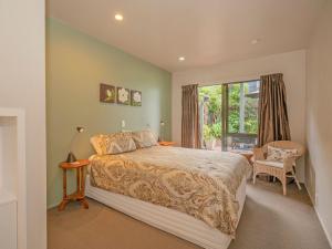 a bedroom with a large bed and a window at The Harbour View Tairua in Tairua +42 photos