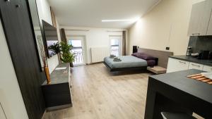a living room with a bed and a kitchen at ESTENSIA Room & Suite in Ferrara