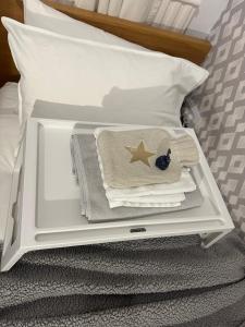 a white tray with towels and a star on a bed at fAiRy DeLL Guesthouse 24-7 check in, cozy lockable rooms, tv, tea tray with choccies, cooling fans, free wifi and parking, COA, all are welcome in Bradford