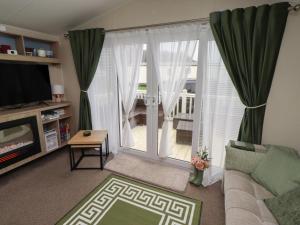 a living room with a couch and a sliding glass door at Homeslea 33 Millennium Gardens in Morpeth