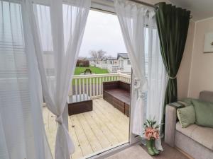 a room with a balcony with a sliding glass door at Homeslea 33 Millennium Gardens in Morpeth