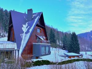 a large house in the snow with a balcony at Spa & Pool VILA ANNA in Halenkov
