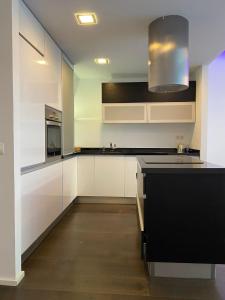 a kitchen with white cabinets and a black counter top at Loft Elegante Norte de Madrid in San Sebastián de los Reyes