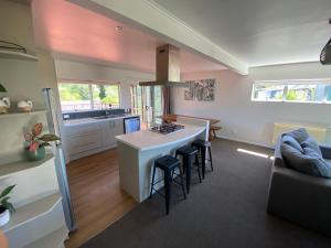 a kitchen and living room with a stove and a couch at The Rock House, Patons Rock in Rangihaeata