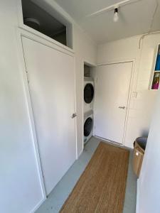 a laundry room with white cabinets and a washer and dryer at The Rock House, Patons Rock in Rangihaeata