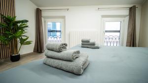 a bedroom with a large bed with two chairs on it at ESTENSIA Room & Suite in Ferrara