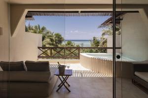 a living room with a tub and a view of the ocean at Azure Horizon Suite in Balcheil