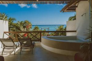 a hot tub on the balcony of a resort with the ocean at Azure Horizon Suite in Balcheil