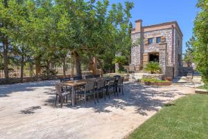 a table and chairs in a yard with a building at Petrino pool house in Athens