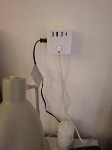 a white outlet with a wire plugged into a wall at CozyNeat Hub in Turin