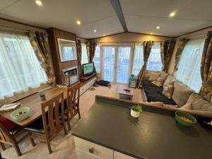 a living room with a couch and a table at Sandy Haven in Ingoldmells