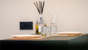 a table with plates and glasses and a vase at ESTENSIA Room & Suite in Ferrara +31 photos