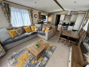 a living room with a couch and a table at Sandy Haven in Ingoldmells