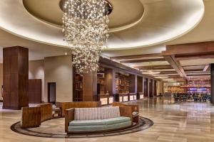 a chandelier hangs from the ceiling of a library at Omni Nashville Hotel in Nashville