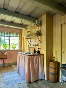 a room with a table in the middle of a room at Heritage-listed country cottages in Eskilstuna