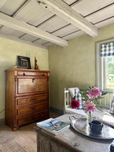 a living room with a wooden table and a dresser at Heritage-listed country cottages in Eskilstuna