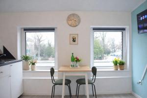 a kitchen with a table and two chairs and a clock at Studio Apartment 1- Komfort & Günstig in Berlin