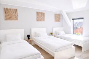two beds in a room with white walls at Studio Apartment 1- Komfort & Günstig in Berlin