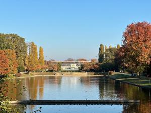 a pond in a park with trees and a building at Studio Apartment 1- Komfort & Günstig in Berlin