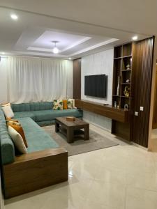 a living room with a green couch and a television at bel appartement juste à côté de McDonald's in Kenitra