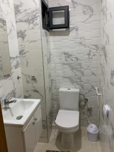 a bathroom with a toilet and a sink and a tv at bel appartement juste à côté de McDonald's in Kenitra +17 photos