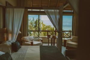 a bedroom with a bed and a view of the ocean at Coral Breeze Retreat in Balcheil