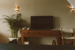a living room with a television on a wooden table at Coral Breeze Retreat in Balcheil
